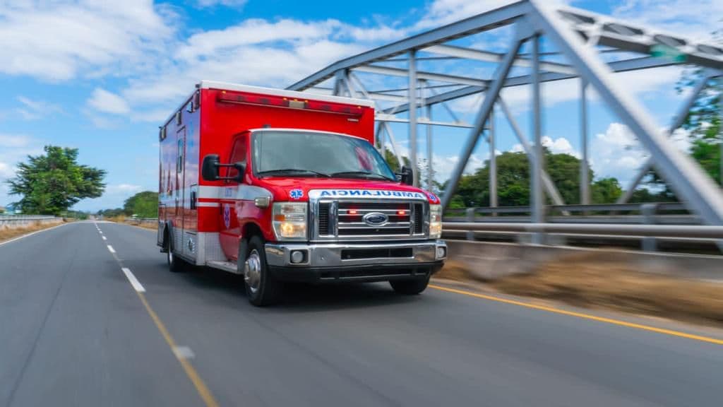 An EMTS ambulance responding at speed on the highway