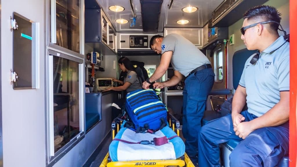 Inside an EMTS advanced life support unit, crew working with the cardiac monitor